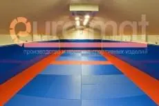 Сине-оранжевые татами и синие стеновые протекторы в зале единоборств